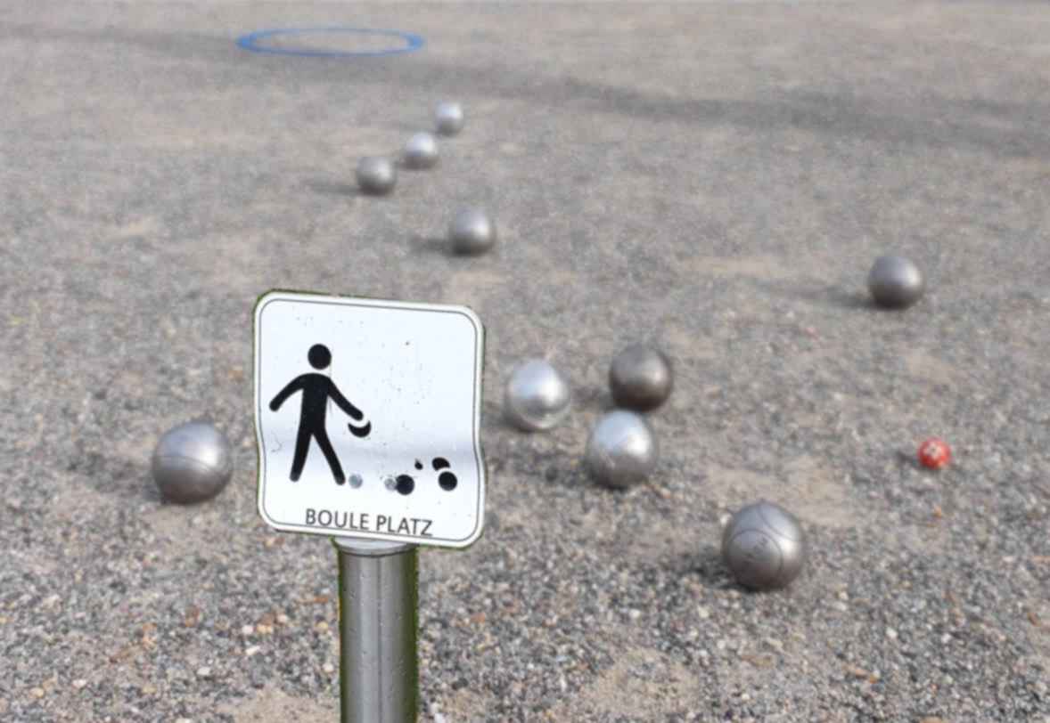 Boulefläche mit kleinem städtischem Schild, das die Fläche als Bouleplatz ausweist